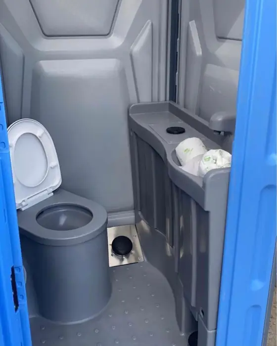 Deluxe porta potty interior with flushing toilet and sink